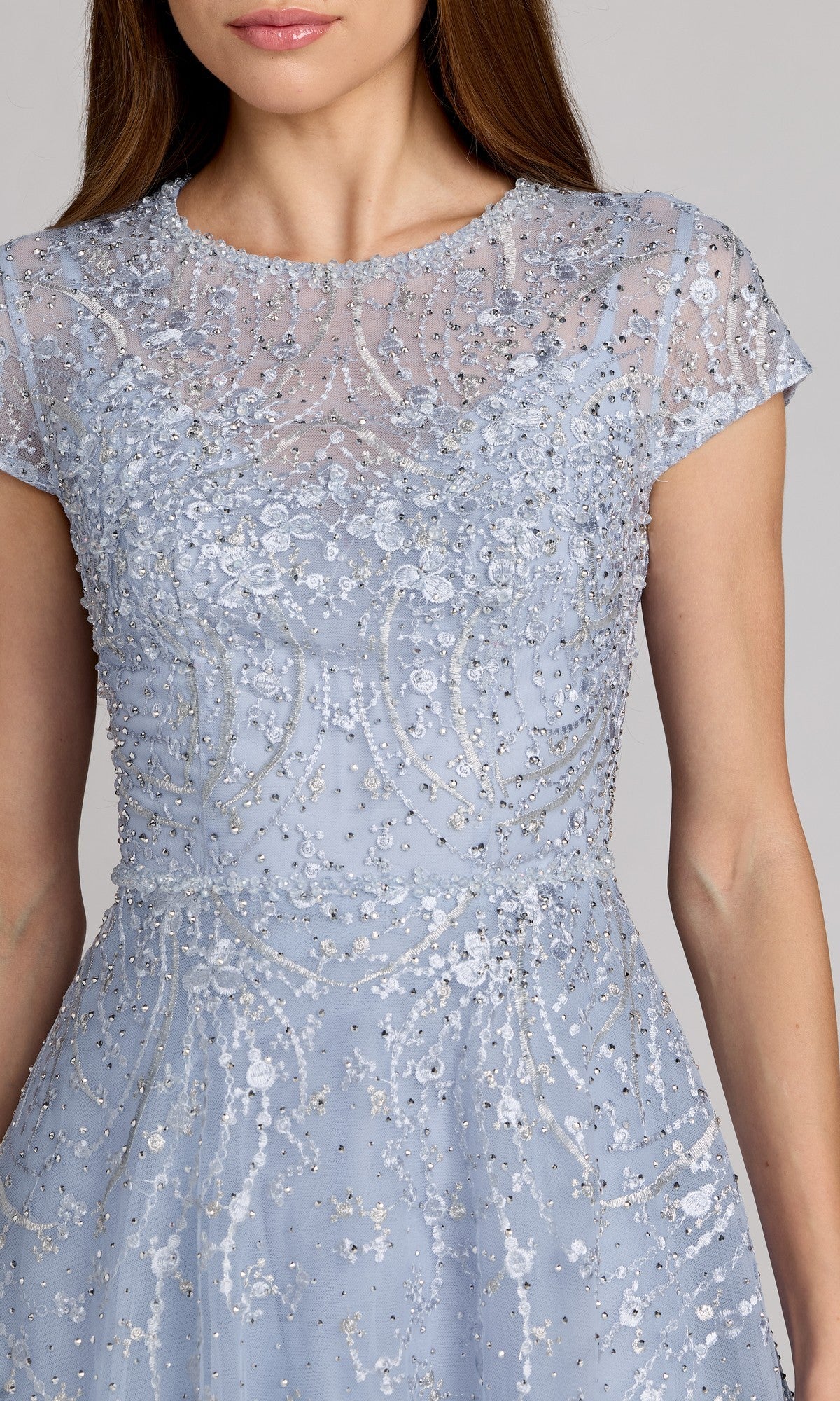 A woman wearing the Tea Length Lilac Party Dress by Mac Duggal (20338), featuring intricate sequin and bead embellishments on sheer fabric.